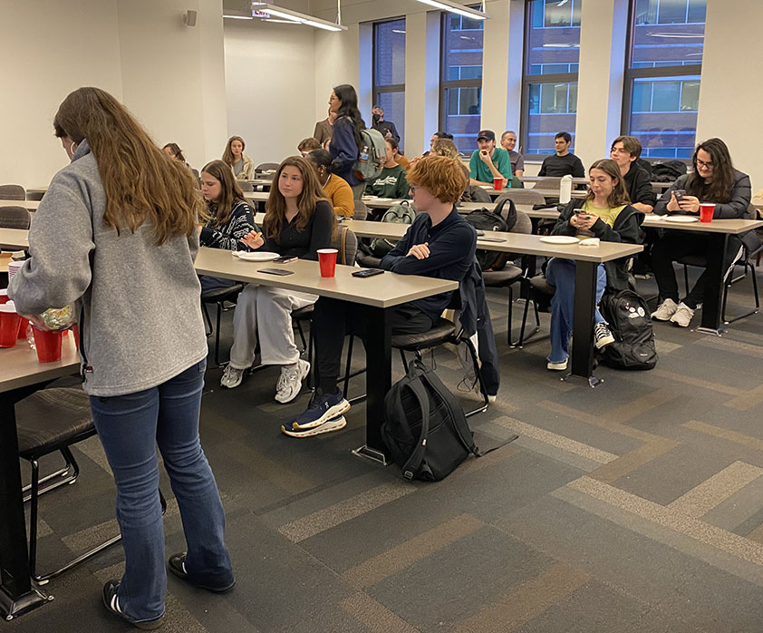 Students sitting and talking before the start of the 2024 Philosophy Faculty Debate